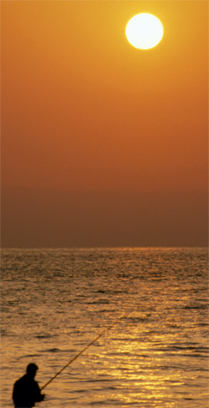 Fisherman under setting sun