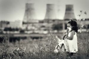 child in a respiratory mask with a doll in her hands walking against power station polluting air coal
