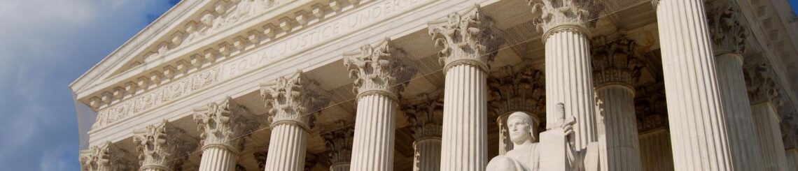 US Supreme Court Building a grand, neoclassical structure with a wide staircase leading up to a row of tall, imposing columns. Above the entrance, the words "Equal Justice Under Law" are inscribed.