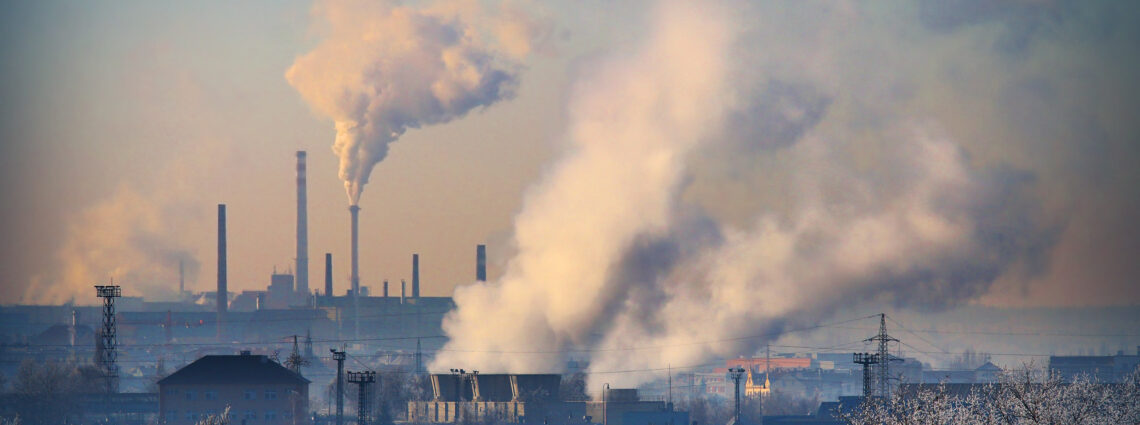 A petrochemical plant with visible smoke rising from its stacks, symbolizing manufacturing processes and pollution.